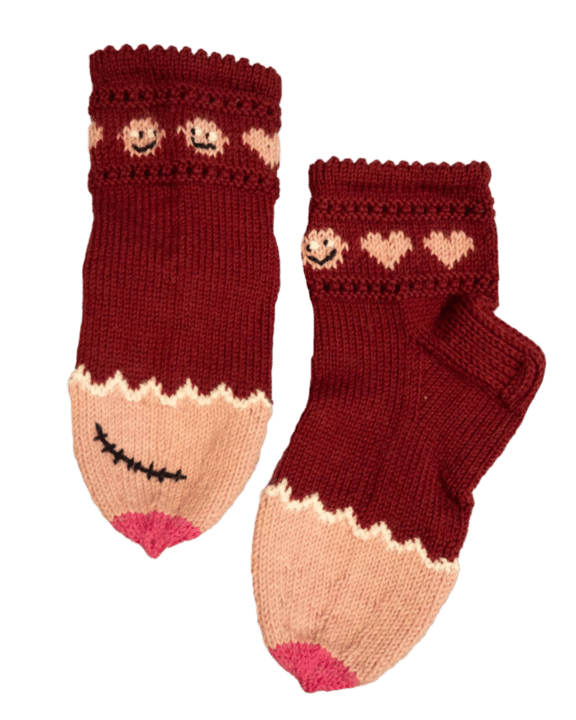 Villasukat, joissa on viininpunaiset varret, joissa on vaaleanpunaisia sydämiä ja kaljupäiset hahmot. Sukkien kärjissä on vaaleanpunaiset, rintoja muistuttavat kärjet, joista toisessa on arpi rintasyöpäleikkauksesta.